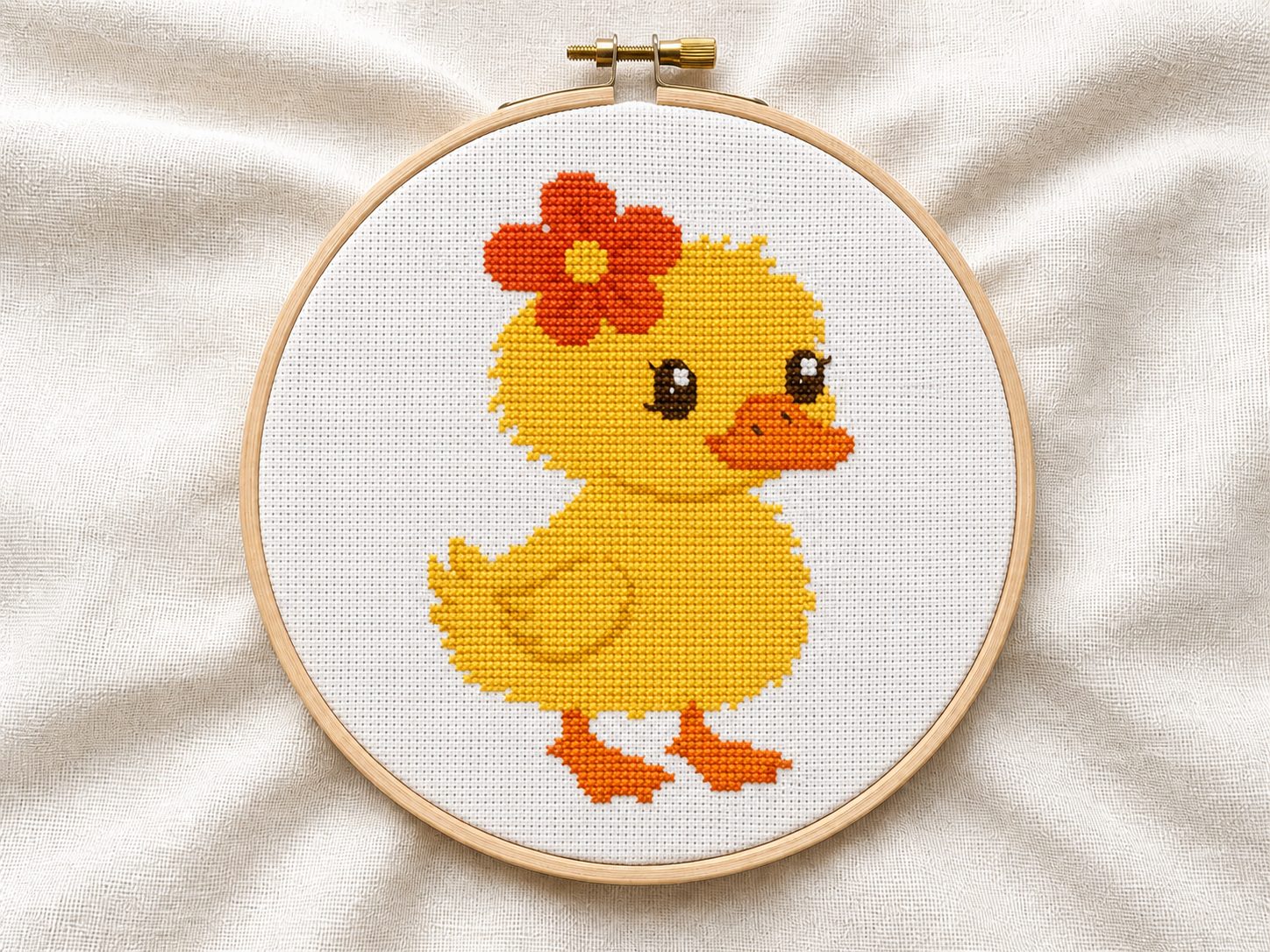Finished Spring Duckling cross stitch pattern in a wooden embroidery hoop