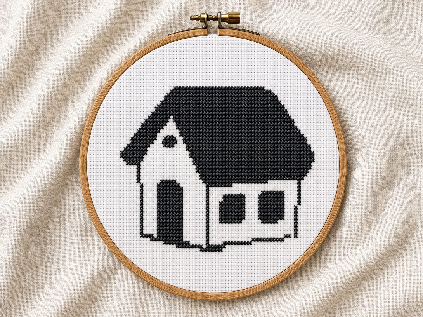 Finished black simple house cross stitch pattern in a wooden embroidery hoop