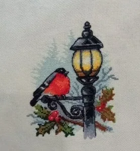Bullfinch on a winter lantern cross stitch finished by a customer